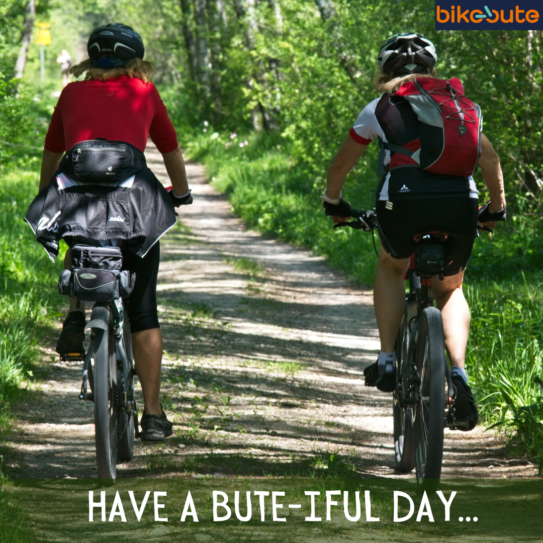 Two people riding a bike through the countryside