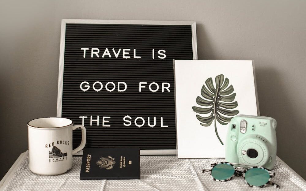 teal fujifilm instax mini camera near white ceramic mug